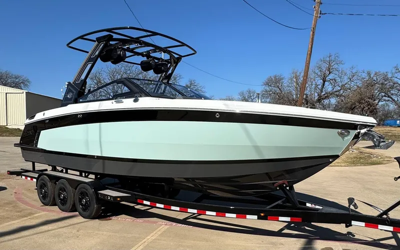 Slide: The Image of 2025 Cobalt R8 Surf boat on trailer, sleek design, black and white color scheme. - 2