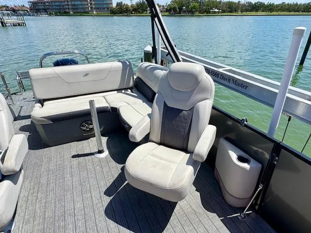 Slide: The Image of 2022 Starcraft CX 25 Q DH pontoon boat with spacious seating on a serene lake. - 14