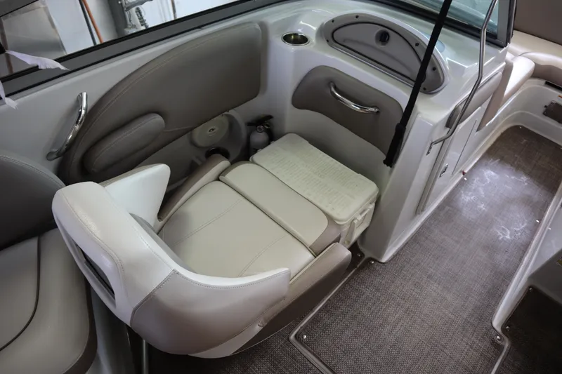 Slide: The Image of 2019 Crownline Eclipse E215 XS boat interior with beige seating and storage. - 13
