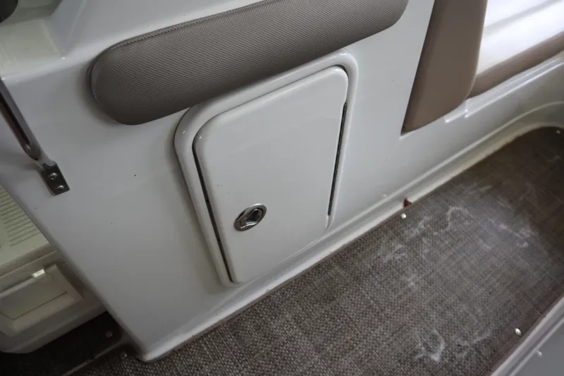 Slide: The Image of 2019 Crownline Eclipse E215 XS interior storage compartment with cushioned seating. - 16