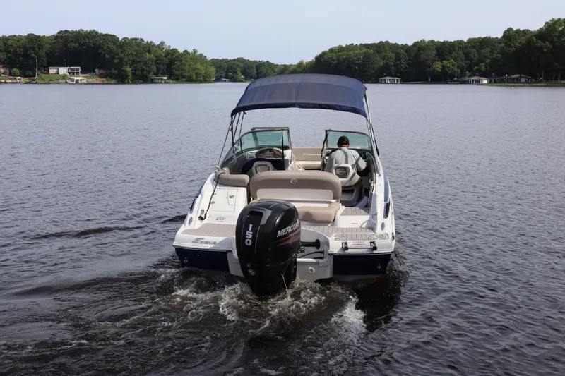 Slide: The Image of 2019 Crownline Eclipse E215 XS boat cruising on a calm lake. - 2