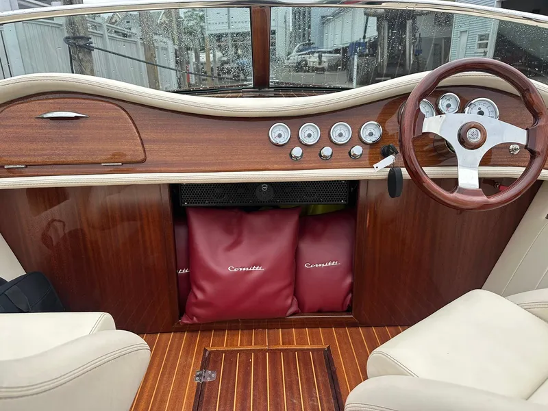 Slide: The Image of Interior of a 2015 Comitti Venezia 22 boat with wooden dashboard and steering wheel. - 14