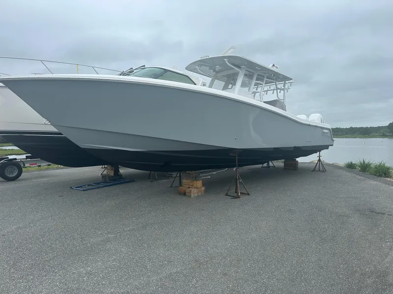 Slide: The Image of 2020 Invincible 39 Open Fisherman boat on stands, overcast day, near water. - 0