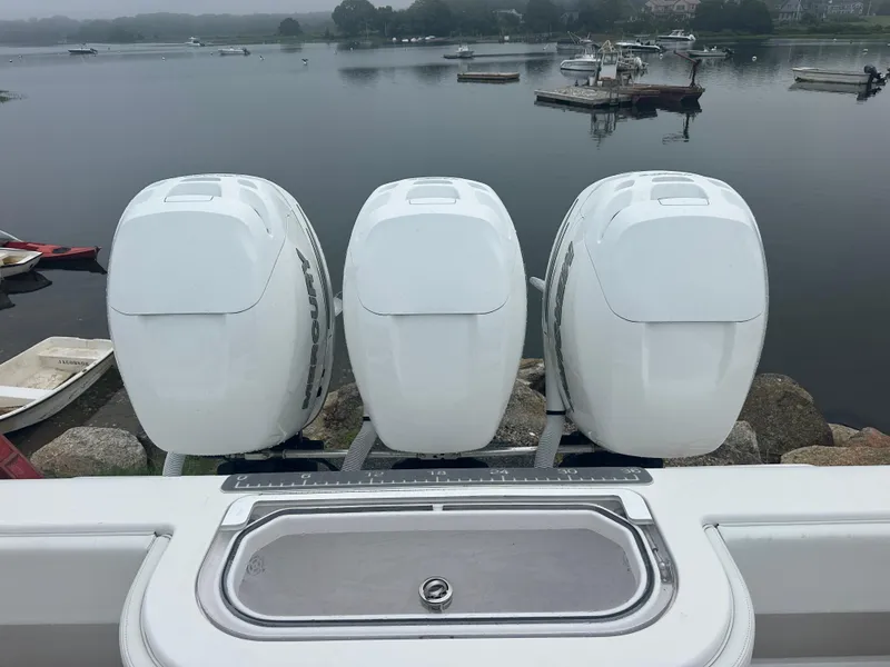 Slide: The Image of Triple Mercury outboard engines on a 2020 Invincible 39 Open Fisherman boat by a calm lake. - 13