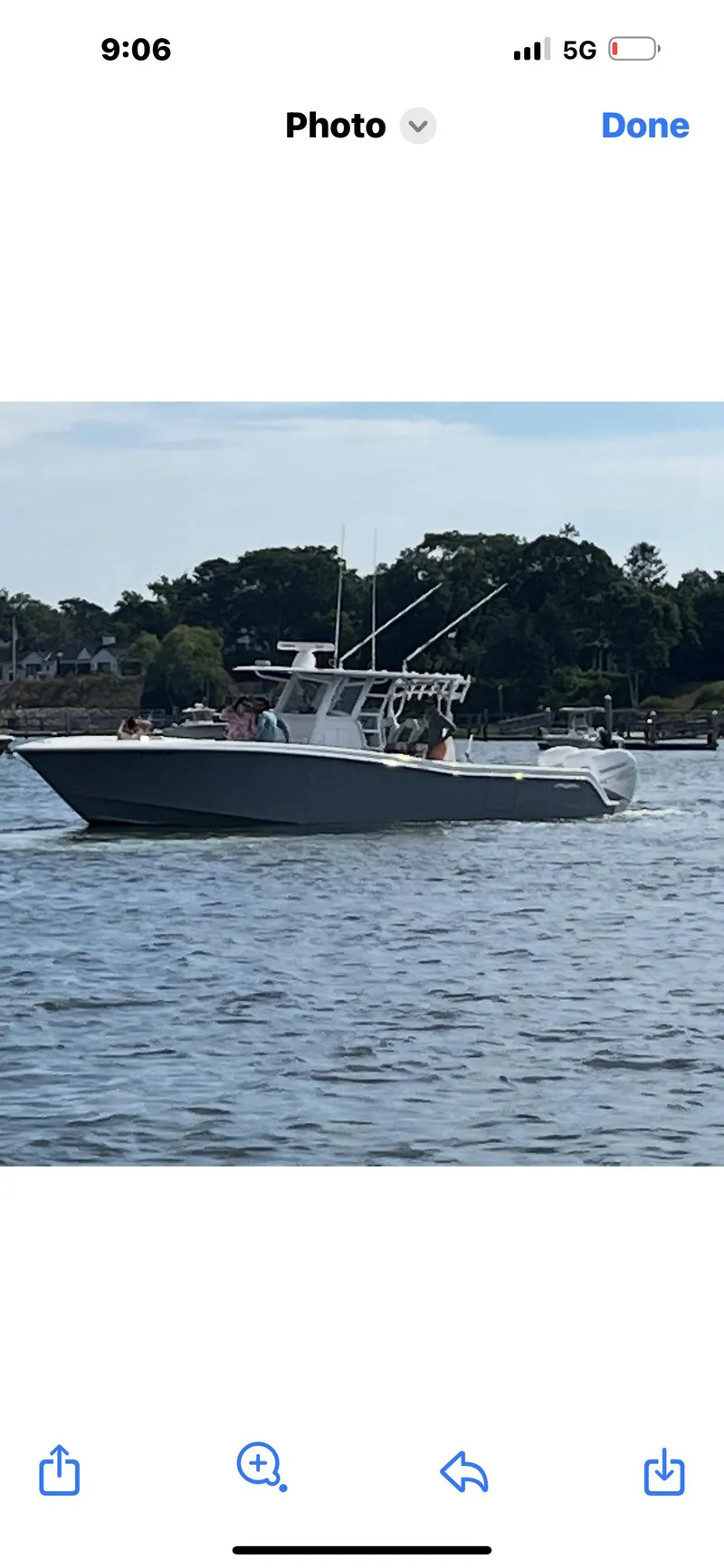 Slide: The Image of 2020 Invincible 39 Open Fisherman boat on water, side view, with trees in background. - 2