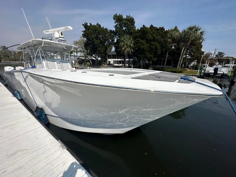 The Image of 2021 SeaHunter 46 CTS boat docked at marina, sleek design, calm water reflection. - 0