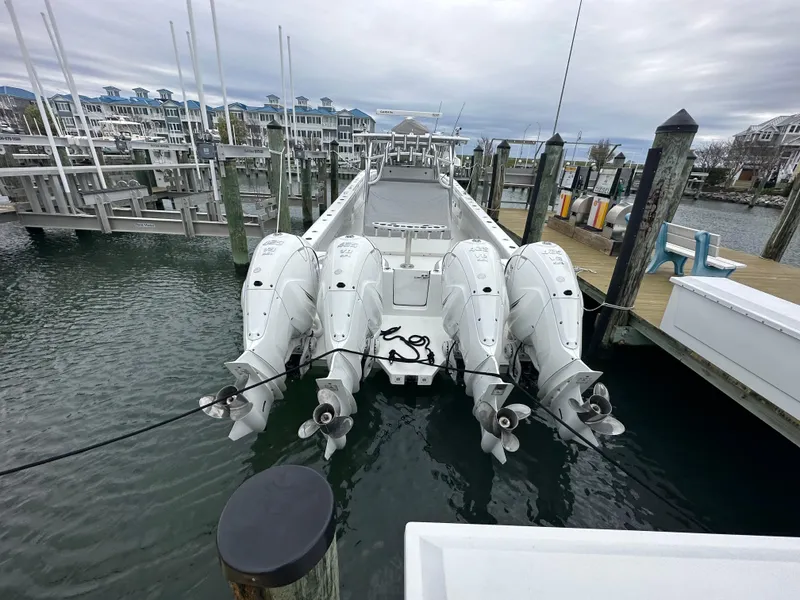 Slide: The Image of 2021 SeaHunter 46 CTS boat docked with four powerful outboard engines. - 11