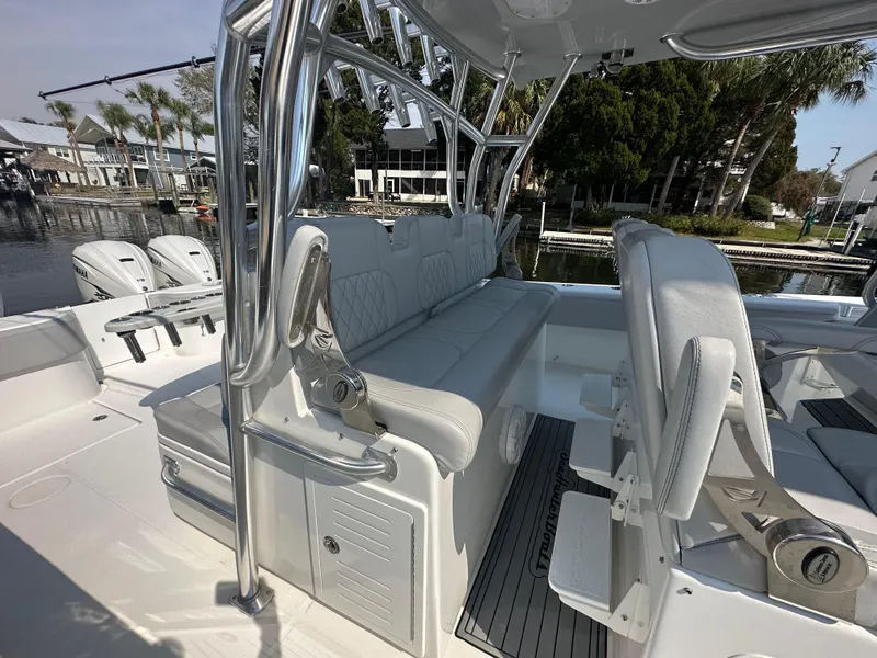 Slide: The Image of 2021 SeaHunter 46 CTS boat interior with seating and rod holders, docked by palm trees. - 5