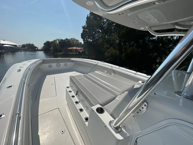 Slide: The Image of 2021 SeaHunter 46 CTS boat deck with seating, docked by a scenic waterfront. - 7