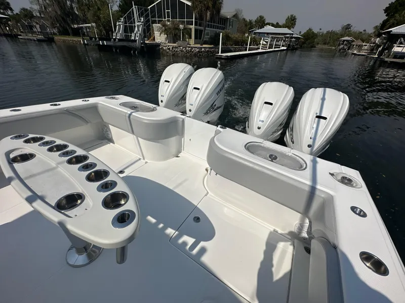 Slide: The Image of 2021 SeaHunter 46 CTS boat with triple Yamaha V8 engines, docked near waterfront homes. - 8