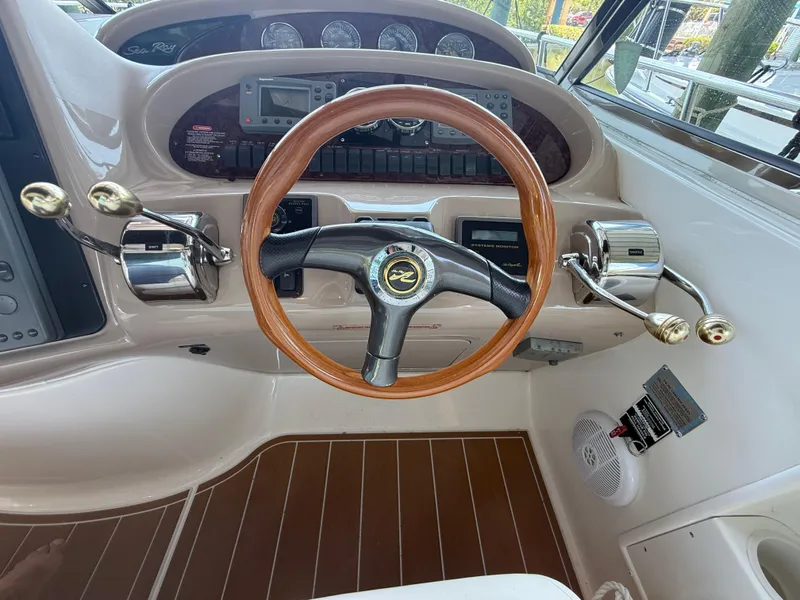 Slide: The Image of 2003 Sea Ray 380 Sundancer helm with wooden steering wheel and control panel. - 21