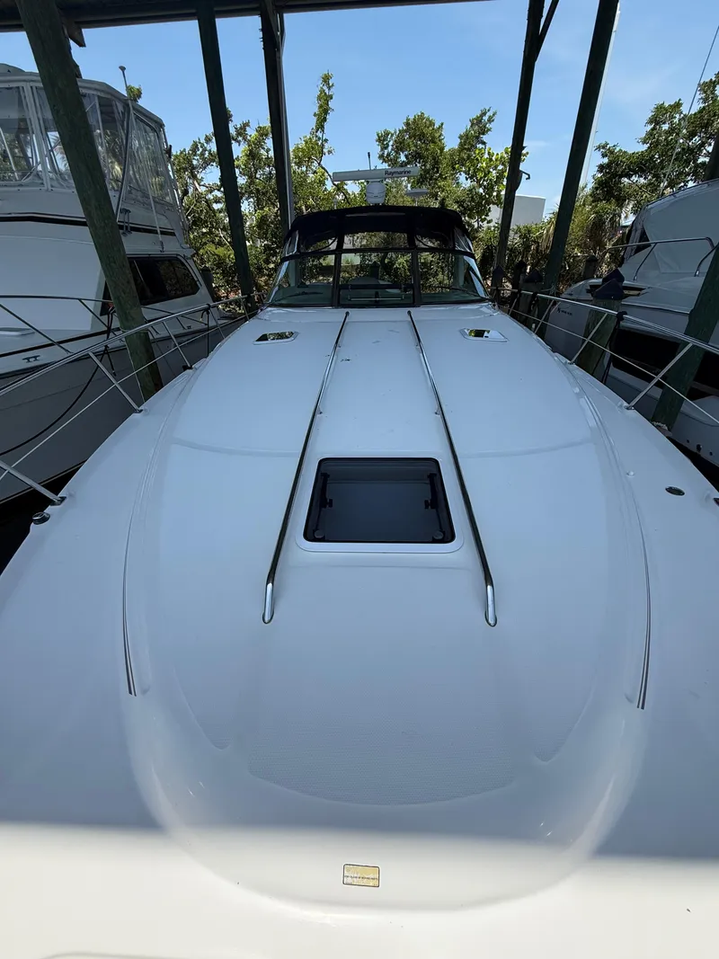 Slide: The Image of 2003 Sea Ray 380 Sundancer yacht docked, showcasing sleek white deck design. - 8