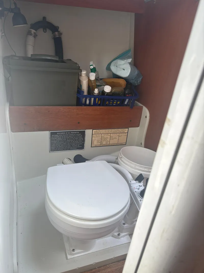 Slide: The Image of Interior of 1987 J Boats J29 showing compact marine toilet and storage area. - 31