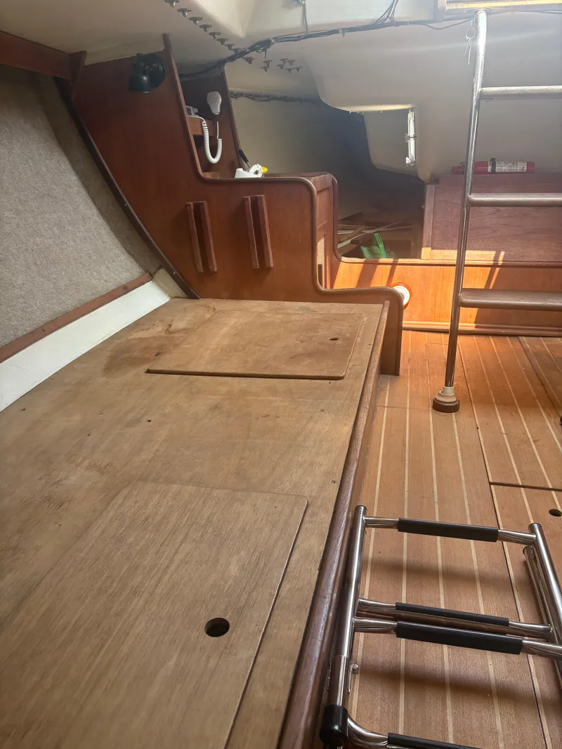 Slide: The Image of Interior of 1987 J Boats J29 sailboat, featuring wooden surfaces and ladder. - 33