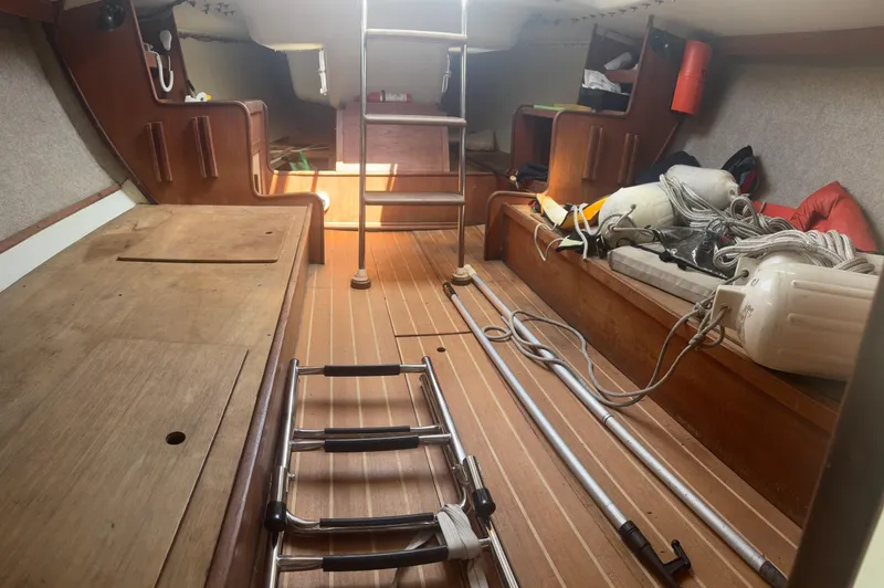 Slide: The Image of Interior of a 1987 J Boats J29 sailboat, featuring wooden flooring and nautical equipment. - 35