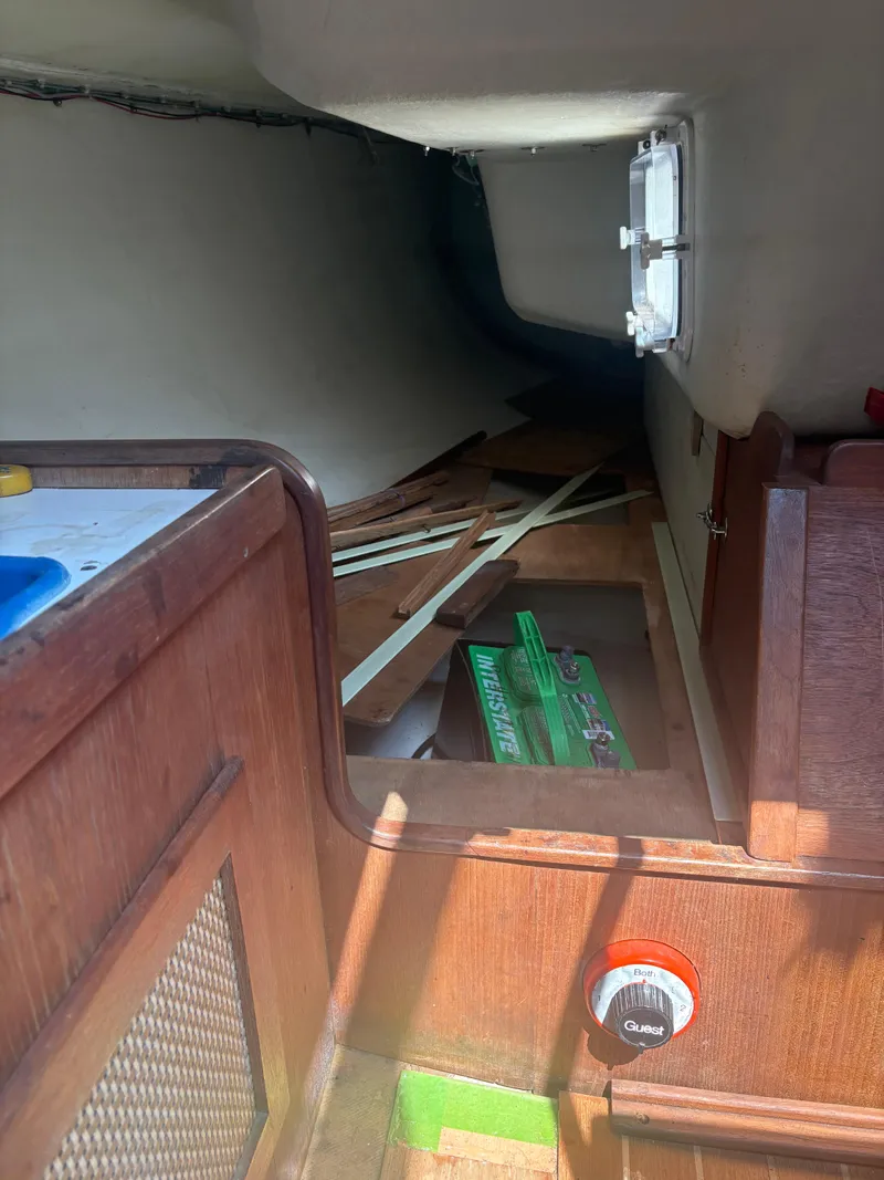 Slide: The Image of Interior of a 1987 J Boats J29 sailboat, showing wooden cabinetry and storage area. - 36