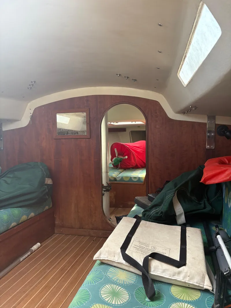 Slide: The Image of Interior of a 1987 J Boats J29 sailboat with wooden paneling and colorful cushions. - 44