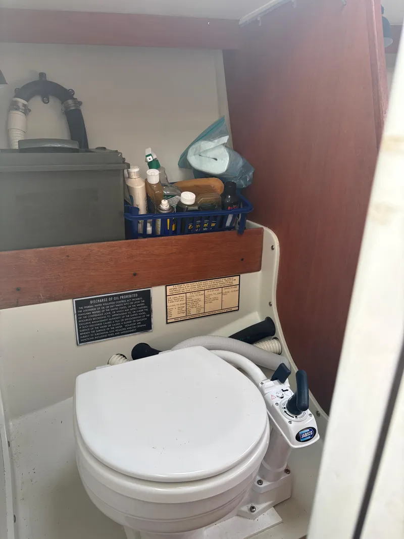 Slide: The Image of 1987 J Boats J29 marine toilet with storage shelf and toiletries. - 47