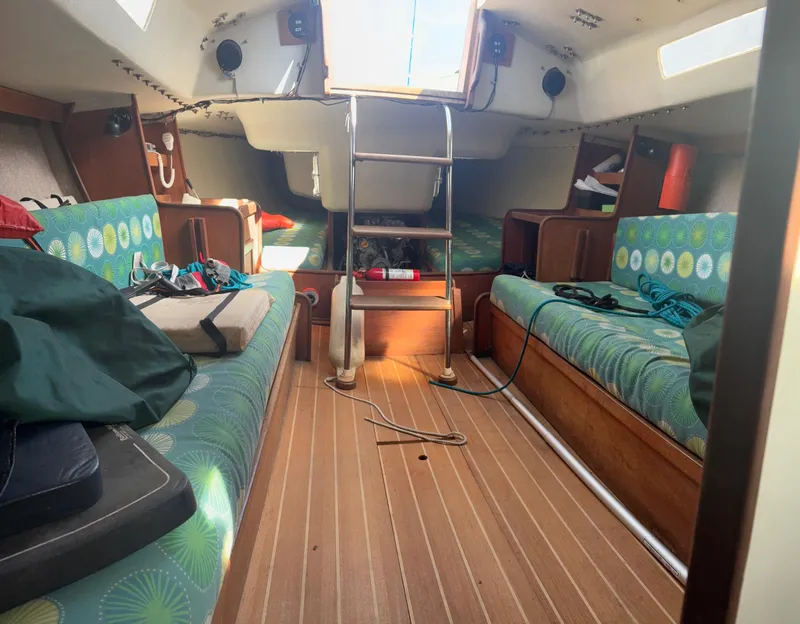 Slide: The Image of Interior of 1987 J Boats J29 sailboat with colorful seating and wooden flooring. - 49