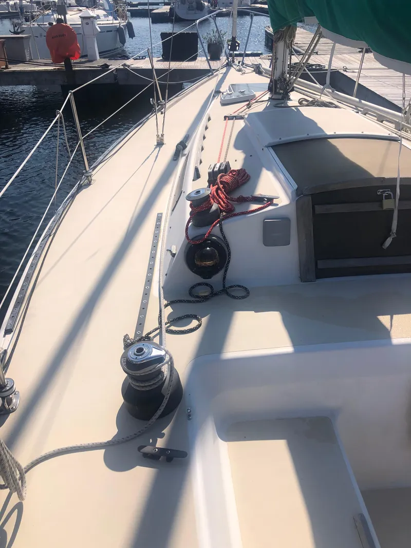 Slide: The Image of 1987 J Boats J29 sailboat deck with winches and ropes in a marina. - 8