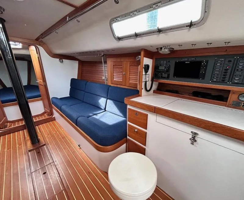 Slide: The Image of Interior of 2006 J Boats J/124 sailboat with blue seating and wooden cabinetry. - 25
