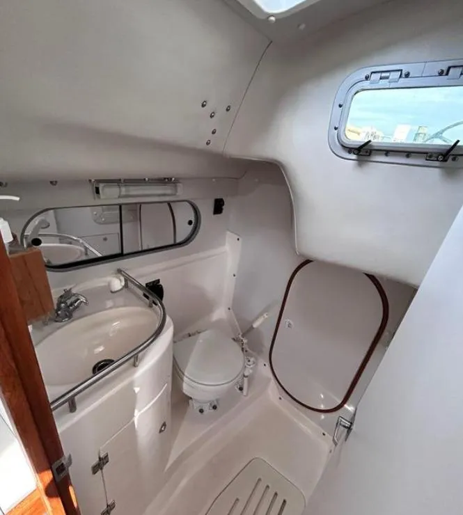 Slide: The Image of 2006 J Boats J/124 yacht bathroom with sink, toilet, and porthole window. - 31