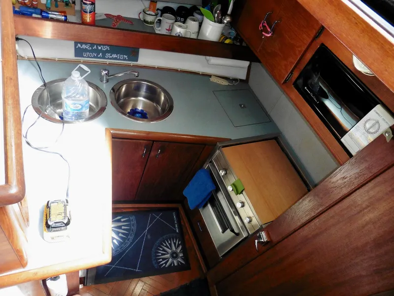 Slide: The Image of Interior of a 1992 Bayliner 3288 Motoryacht kitchen with sink, stove, and wooden cabinets. - 16