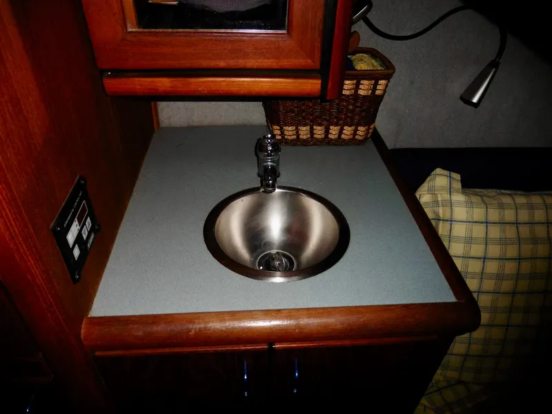 Slide: The Image of 1992 Bayliner 3288 Motoryacht interior with sink, wooden cabinetry, and plaid cushion. - 25