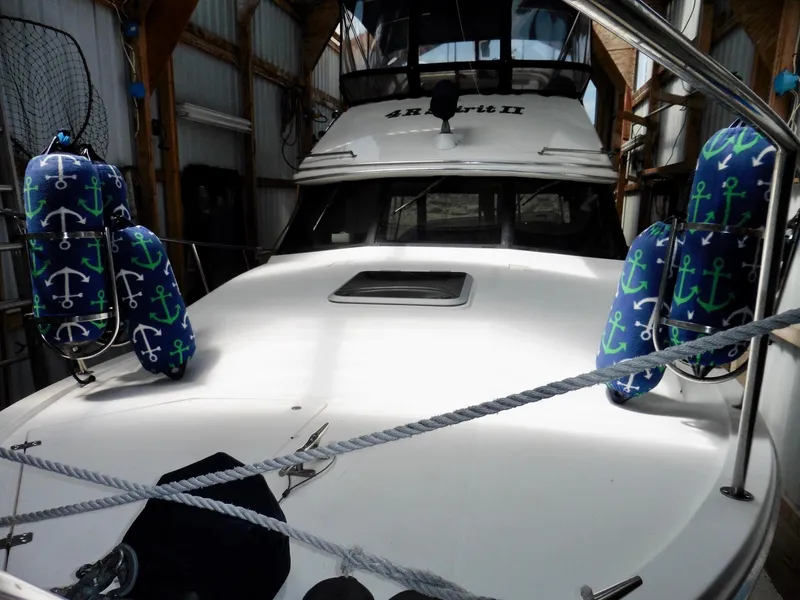 Slide: The Image of 1992 Bayliner 3288 Motoryacht in dock, featuring anchor-themed fenders. - 5