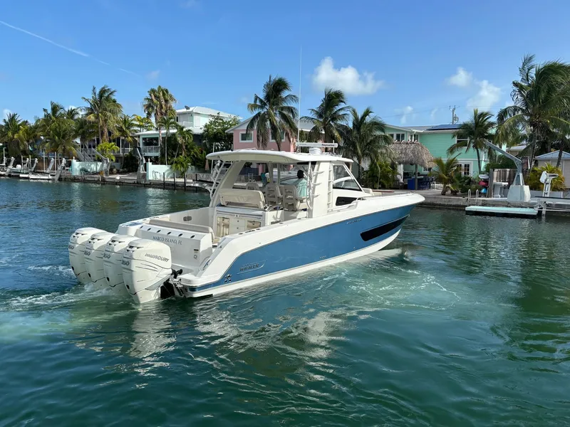 Slide: The Image of 2017 Boston Whaler 420 Outrage boat cruising in tropical waters near palm trees. - 12