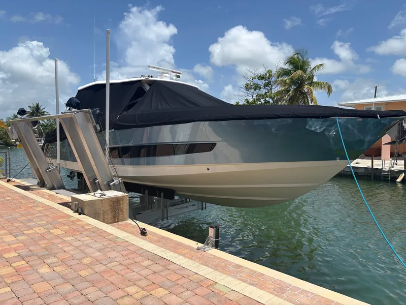 Slide: The Image of 2017 Boston Whaler 420 Outrage on lift by waterfront, under clear sky. - 13