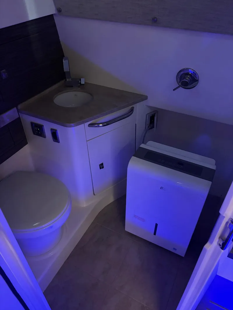 Slide: The Image of 2017 Boston Whaler 420 Outrage bathroom with sink, toilet, and storage. - 14