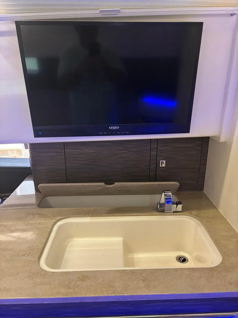 Slide: The Image of Modern kitchen area in a 2017 Boston Whaler 420 Outrage with sink and TV. - 15