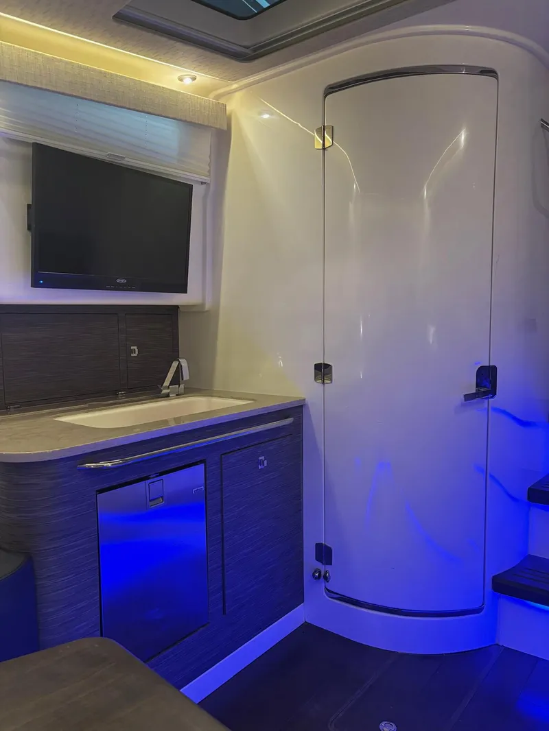 Slide: The Image of Interior of 2017 Boston Whaler 420 Outrage with modern kitchenette and ambient lighting. - 16