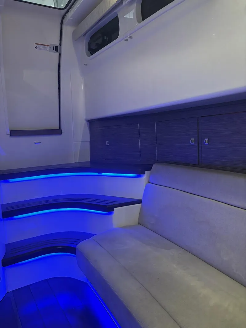Slide: The Image of Interior of 2017 Boston Whaler 420 Outrage with blue LED lighting and seating. - 18