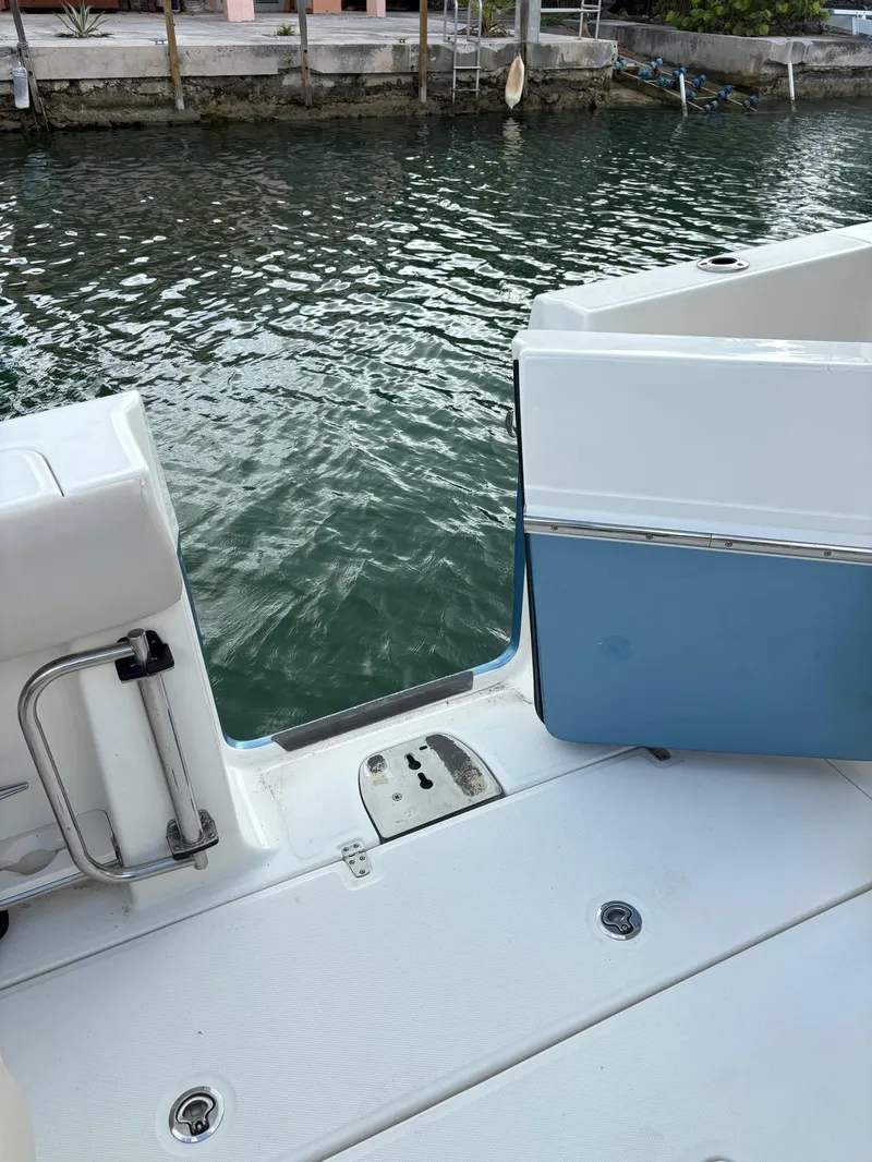 Slide: The Image of 2017 Boston Whaler 420 Outrage boat deck with open side door by the water. - 34