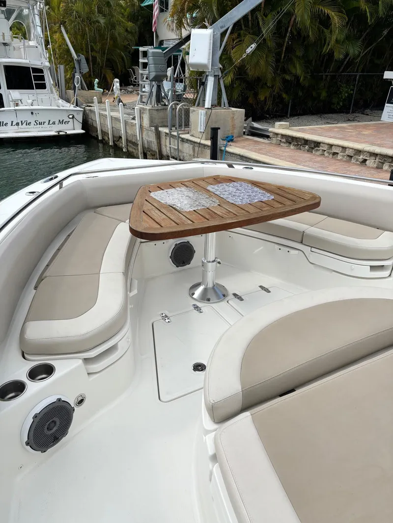 Slide: The Image of 2017 Boston Whaler 420 Outrage boat interior with cushioned seating and wooden table. - 36