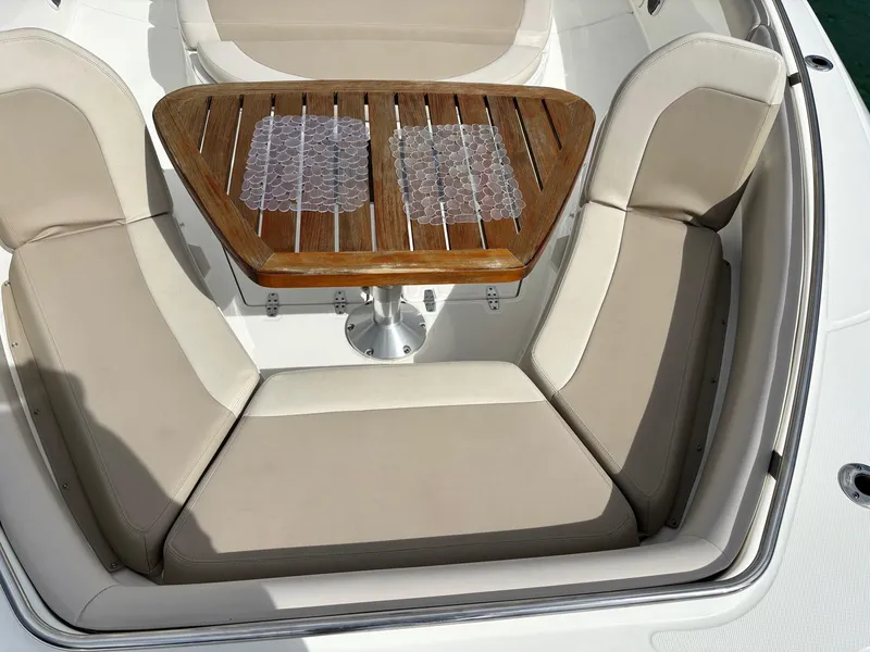 Slide: The Image of 2017 Boston Whaler 420 Outrage boat seating area with wooden table and cushioned seats. - 38