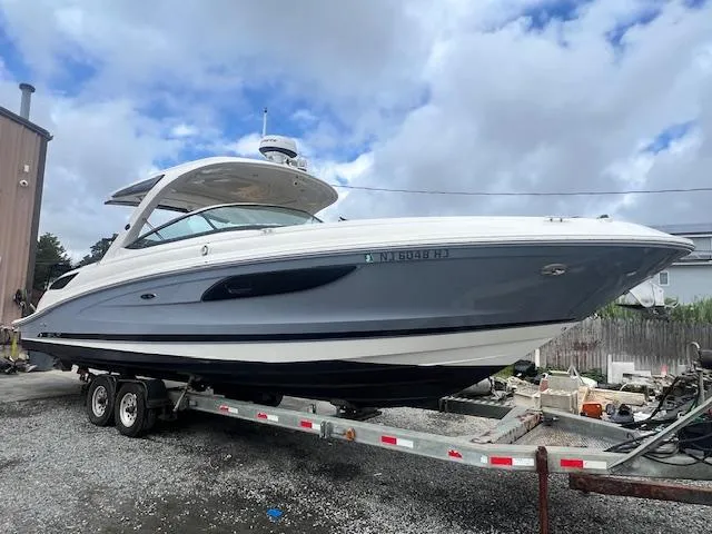 The Image of 2016 Sea Ray 350 SLX boat on trailer, under cloudy sky. - 0