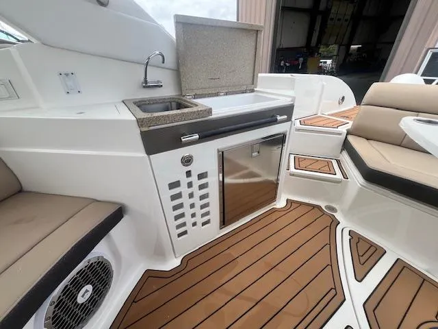 Slide: The Image of Luxurious 2016 Sea Ray 350 SLX boat interior with kitchenette and seating area. - 11