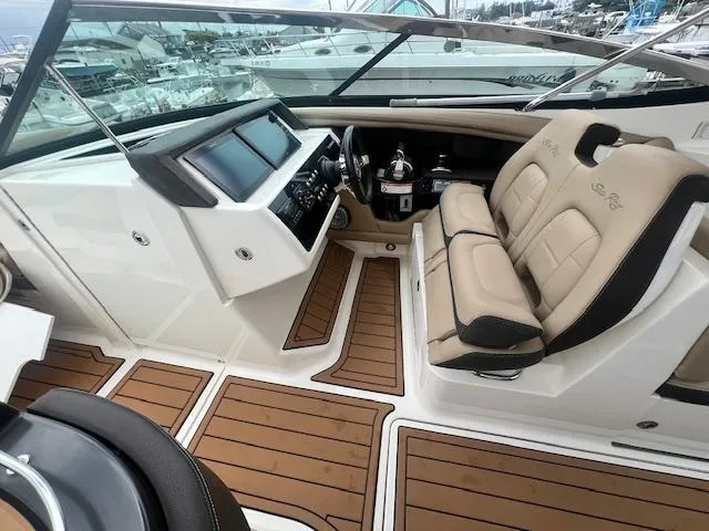 Slide: The Image of 2016 Sea Ray 350 SLX boat interior with beige seating and modern dashboard. - 2