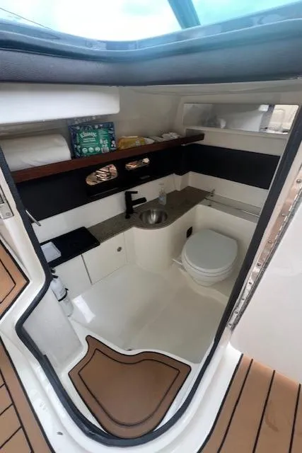 Slide: The Image of 2016 Sea Ray 350 SLX boat interior with compact bathroom, sink, and toilet. - 20
