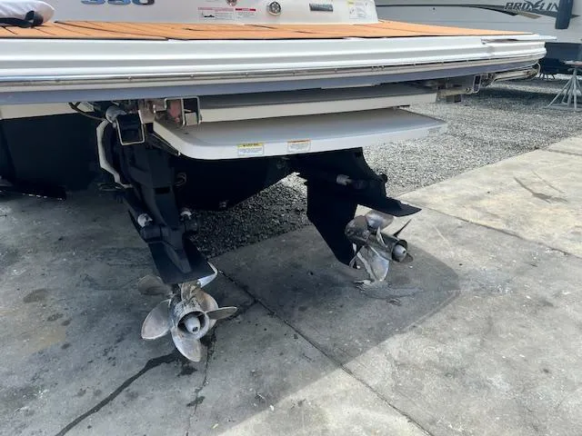 Slide: The Image of 2016 Sea Ray 350 SLX boat with dual propellers on a concrete surface. - 24