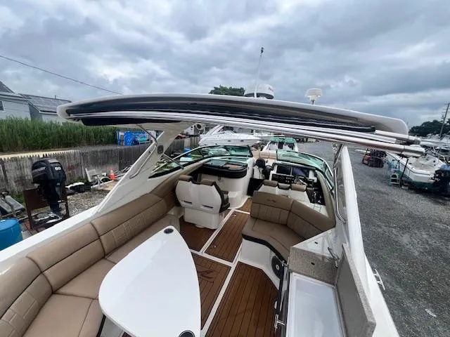 Slide: The Image of 2016 Sea Ray 350 SLX boat with spacious seating and sleek design, docked under cloudy skies. - 9