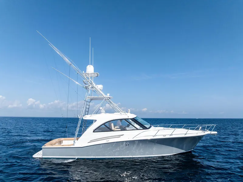 Slide: The Image of 2016 Hatteras Express Sportfish yacht cruising on open sea under clear blue sky. - 13