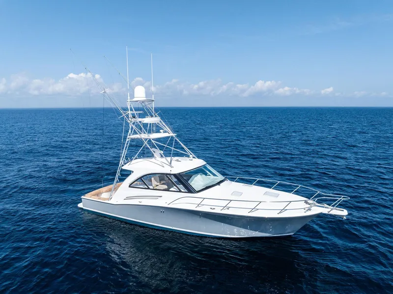 Slide: The Image of 2016 Hatteras Express Sportfish yacht cruising on open ocean under clear blue sky. - 14