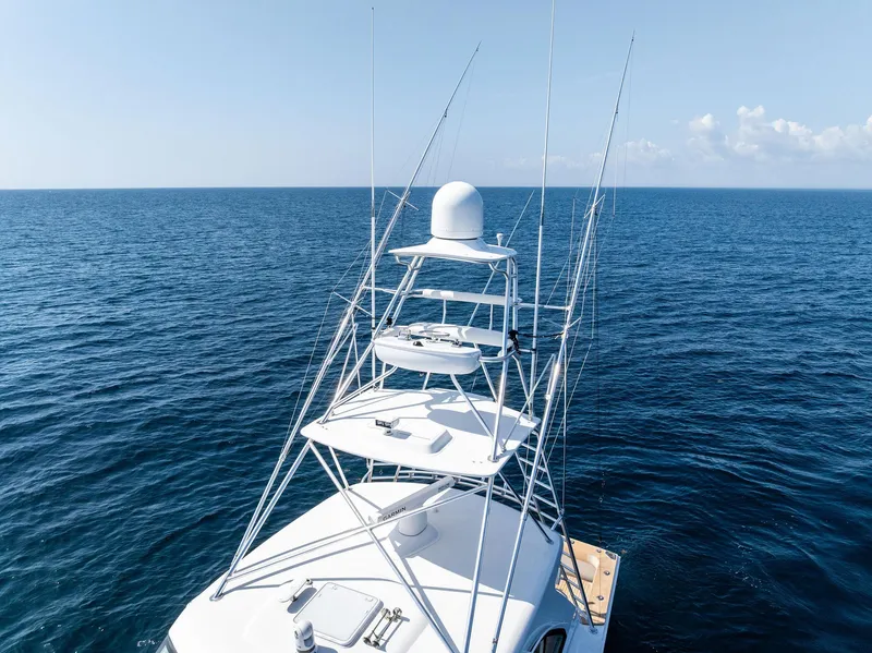 Slide: The Image of 2016 Hatteras Express Sportfish yacht on open sea, featuring a tall tower. - 18