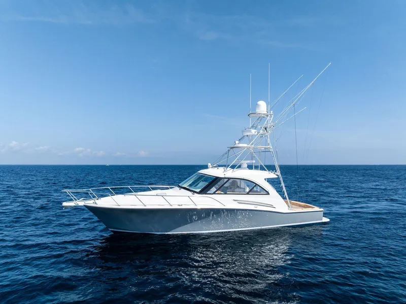 Slide: The Image of 2016 Hatteras Express Sportfish yacht on open ocean under clear blue sky. - 23