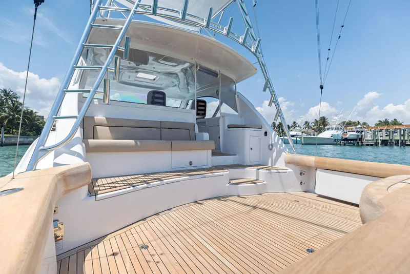 Slide: The Image of 2016 Hatteras Express Sportfish boat with spacious deck and seating, docked by the water. - 26