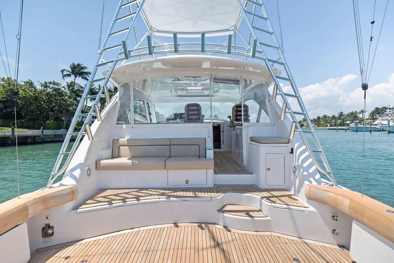 Slide: The Image of 2016 Hatteras Express Sportfish yacht with spacious deck and seating, docked by tropical waters. - 27